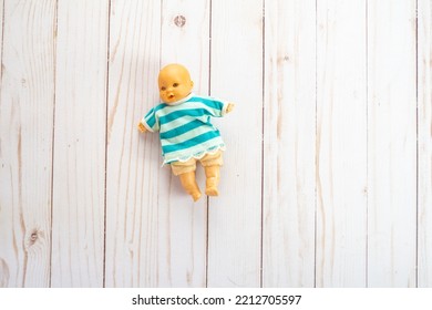 Old Plastic Mini Baby Doll Toy Wearing A Striped Sweater. Toy Is Antique From The 1980s