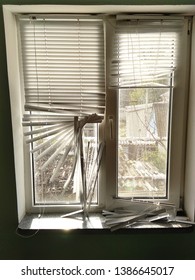 Old Plastic Window With Torn Blinds. Broken Blinds System At The House.