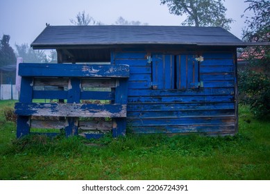 Old Playhouse With Chipped Paint In A Backyard In Autumn