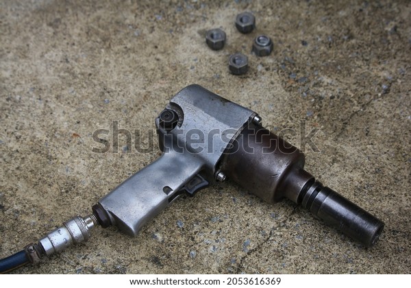 old\
pneumatic impact wrench on garage concrete\
floor