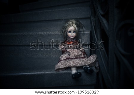 Old porcelain doll on the stairs
