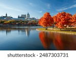 Old Port of Montreal in autumn. Red maples and old Montreal buildings skyline reflected on St. Lawrence River. Fall foliage season in Montreal, Quebec, Canada.