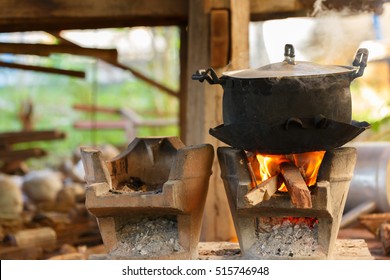 Old Pot Standing On Wood Burning Stove With Steam From Cooking At Thailand