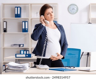 Old pregnant woman working in the office - Powered by Shutterstock