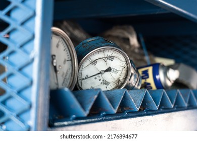 An Old Pressure Gauge Or Manometer In Poor Condition (broken Glass), Which Is Kept On Metal Rack In Workshop Store. Industrial Equipment Object.