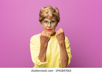 Old Pretty Woman Looking Confident, Angry, Strong And Aggressive, With Fists Ready To Fight In Boxing Position