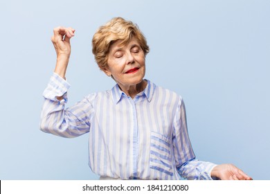 Old Pretty Woman Smiling, Feeling Carefree, Relaxed And Happy, Dancing And Listening To Music, Having Fun At A Party