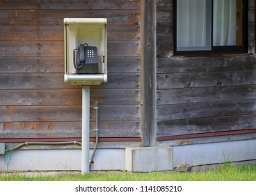 Old public payphone outside wooden building - Shutterstock ID 1141085210