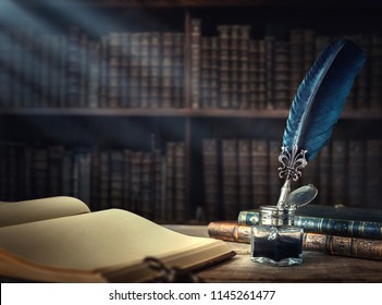 Old quill pen, books and vintage inkwell on wooden desk in the old office against the background of the bookcase and the rays of light. Conceptual background on history, education, literature topics. - Shutterstock ID 1145261477