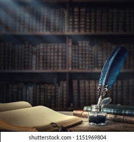 Old Quill Pen, Books And Vintage Inkwell On Wooden Desk In The Old Office Against The Background Of The Bookcase And The Rays Of Light. Conceptual Background On History, Education, Literature Topics.