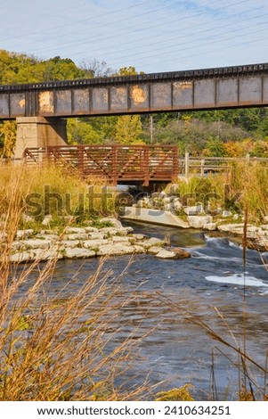 Old Railroad and Modern Footbridge Over Stream in Natural Setting