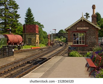 An old railway station with signal box, water tank and goods wagon