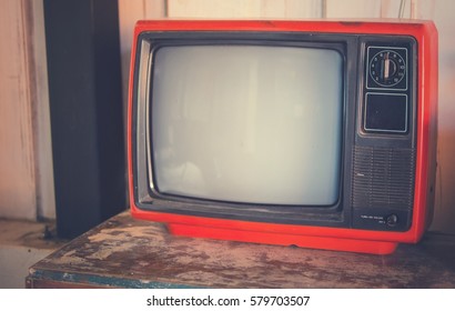 Old Red Analog TV Placed On An Old Wooden Table In An Ancient Living Room.Vintage Style Color Tone