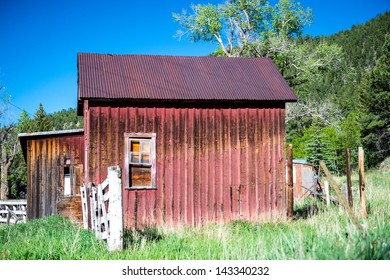 Old Red Bard With Blue Sky And White Fence