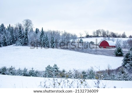 Old red barn in a  Wisconsin, snow covered forest, horizontal