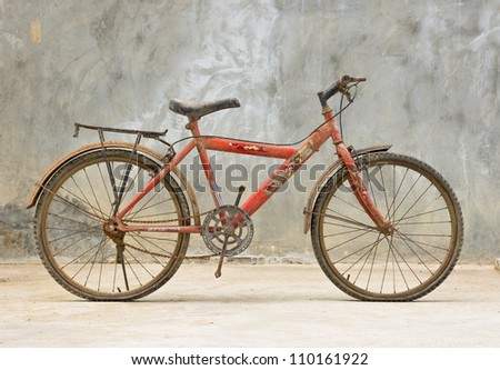 old red bicycle with concrete background