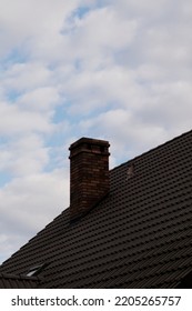 Old Red Brick Chimney On A Background Of The Cloudy Sky