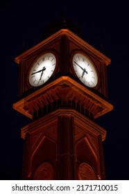 An Old Red Brick Clock Tower With Shades Of Street Lights.