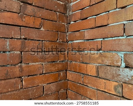 Old Red Brick Wall Corner with Weathered Texture and Gaps in Mortar Joints