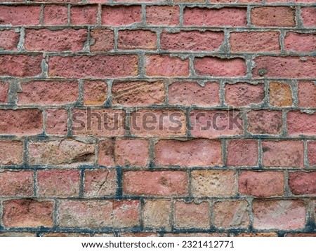 An old red brick wall eroded by acid  rain