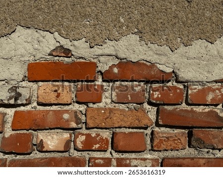 Old red brick wall with weathered mortar texture. Close-up of an old  wall worn and chipped bricks ana visible aged mortar. A rustic texture perfect for architectural, industrial or vintage design.