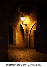Old red bricks wall and light hanging on the wall. Night. Arch. fortress. Holland