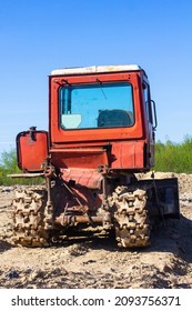 Old Red Bulldozer Against The Blue Sky. Back View.