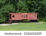 old red caboose has gotten to the end of the line and now sits on display in a child