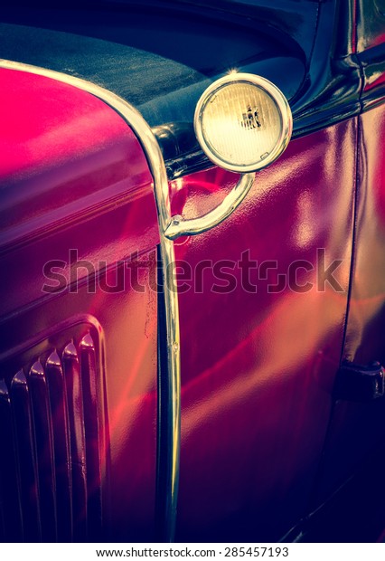 Old red car with\
vintage lamp - detail of retro car. Vintage auto headlight - part\
of antique automobile.