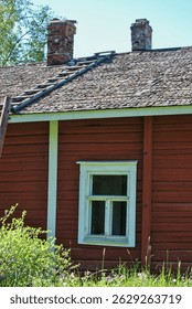 Old red logcabin in Finland. Red cabin next to forest and meadow in summer.