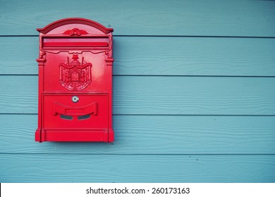 Old red mailbox on wooden walls painted blue, thailand.