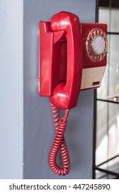 Old Red Phone Hanging On The Wall.