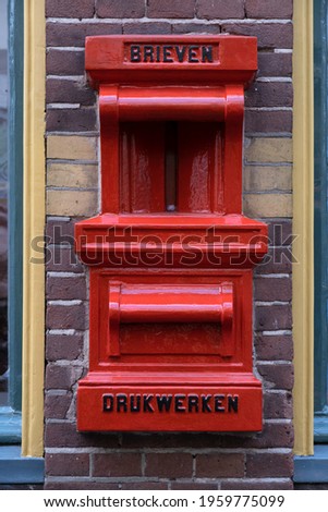 Old red postbox mounted in a brick wall of a house with the text BRIEVEN (letters) and DRUKWERKEN (press-work or printed matter) in Deventer, the Netherlands