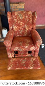 Old Red Recliner Chair, Fireplace Behind And Cup Of Coffee Beside