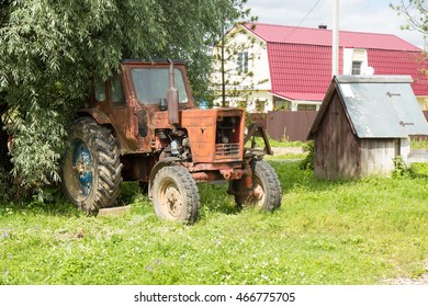 Old red rusty tractor on countryside