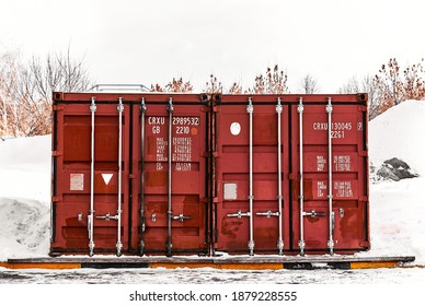 Old red shipping container door with technical characteristics text, background photo texture.