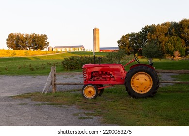 Old red tractor in farm land with rural buildings in soft focus background, St. François, Island of Orleans, Quebec, Canada - Powered by Shutterstock