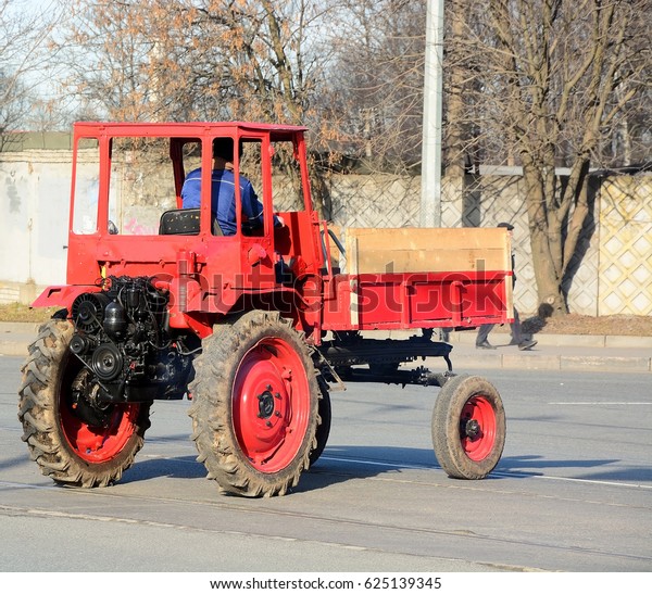Old red tractor on the\
road