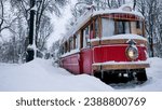 old red tram stuck on the winter road. Public transport covered in snow. Bad weather condition, cold winter blizzard