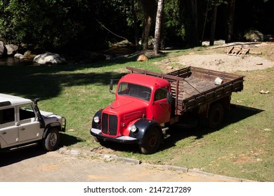 Old Red Truck In Rural Area. Small Family Agribusiness, Automobile. Vehicle Dirty With Dirt, Mud.