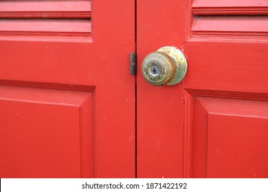 Old Red Wooden Door With Grill, Brass Door Knob Or Handle In Lock Position