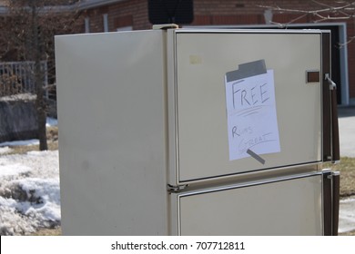 An old refrigerator on the curb of a residential property in Barrie Ontario with a sign that says "Free Runs Great"... 