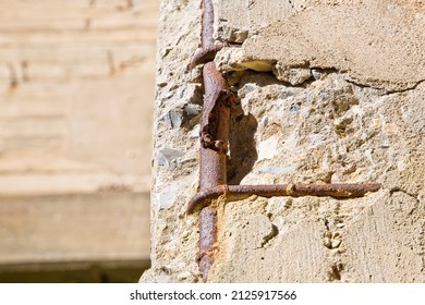 Old reinforced concrete structure with damaged and rusty metallic reinforcement bars.