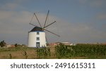 Old restored windmill in Aljezur, Portugal, against the blue sky