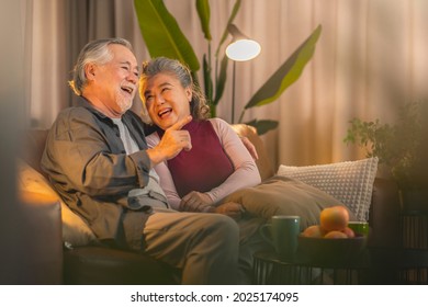 alte asiatische Paare im Ruhestand, die zuhause fernsehen, altes asiatisches Ehepaar jubeln Sportspiele Wettbewerb zusammen mit lachen Lächeln Sieg auf Sofa Couch auf Wohnzimmer Isolation Aktivität