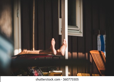 An Old Retired Senior Man Is Relaxing And Sunbathing On The Porch Of His Summer House. He Is Enjoying The Quality Of Life After Many Years Of Hard Work.
