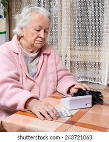 Old  Retired Woman Taking Blood Pressure At Home