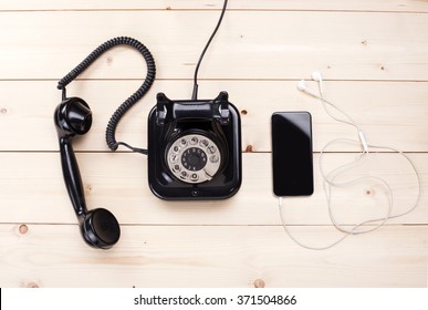 Old Retro Black Phone And New Cell Phone On Wooden Board, Top View, DOF, Focus On Phone