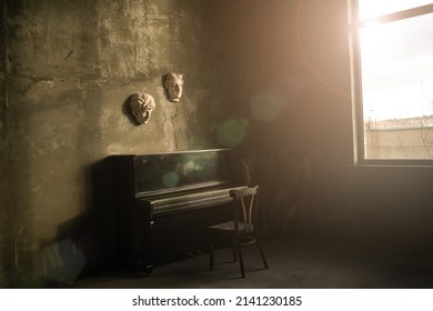 Old retro black piano keyboards in the loft design room with concrete wall and vintage antique bust decoration. Cinematic photo.