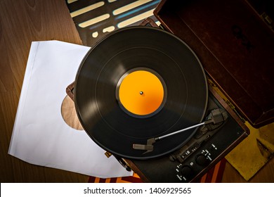 Old retro case gramophone player with vinyl plaing and vinyl covers top view - Shutterstock ID 1406929565
